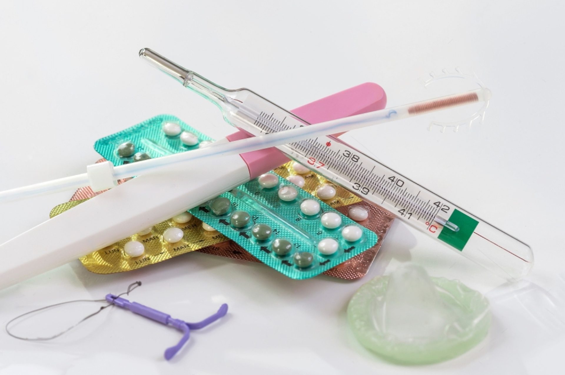 óvszerek és fogamzásgátló tabletták egymáson az asztalon